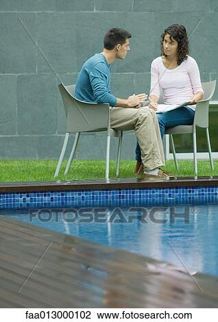Man and woman talking by poolside View Large Photo Image Stock Image - Man and woman talking by poolside. Fotosearch
