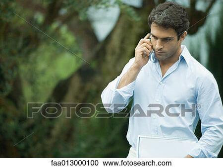 Man using cell phone outdoors View Large Photo Image Stock Image - Man using cell phone outdoors. Fotosearch