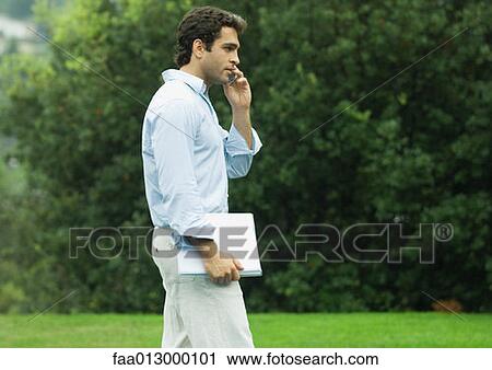 Man using cell phone outdoors View Large Photo Image Stock Image - Man using cell phone outdoors. Fotosearch