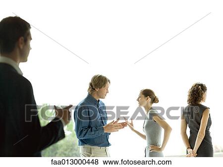 Stock Photo - Man watching couple talking during cocktail party. Fotosearch