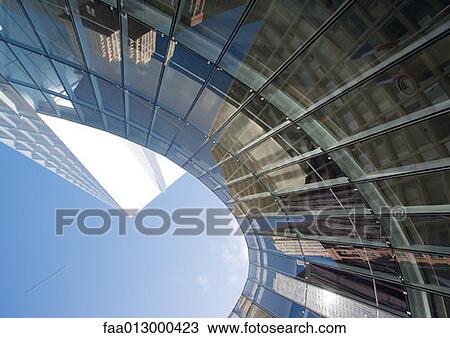 Stock Image - Skyscraper with reflection of buildings on facade, low angle, abstract view. Fotosearch
