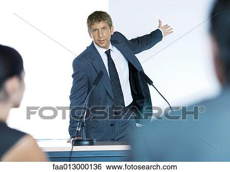Speaker standing next to microphones during seminar View Large Photo Image Stock Photograph - Speaker standing next to microphones during seminar. Fotosearch