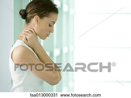 Stock Image - Woman looking down, holding neck. Fotosearch