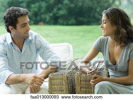 Woman showing man cell phone, outdoors in armchairs View Large Photo Image Stock Image - Woman showing man cell phone, outdoors in armchairs. Fotosearch