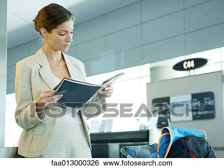 Woman standing in airport near departure gate View Large Photo Image Stock Photograph - Woman standing in airport near departure gate. Fotosearch