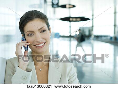 Woman using cell phone in airport View Large Photo Image Stock Image - Woman using cell phone in airport. Fotosearch