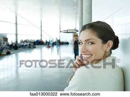 Woman using cell phone in airport View Large Photo Image Stock Image - Woman using cell phone in airport. Fotosearch