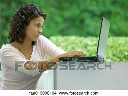Picture - Woman using laptop outdoors. Fotosearch