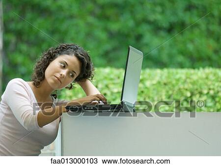 Stock Image - Woman using laptop outdoors. Fotosearch