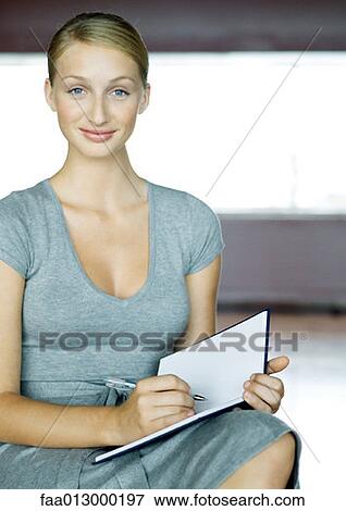 Young businesswoman writing in agenda View Large Photo Image Stock Photo - Young businesswoman writing in agenda. Fotosearch