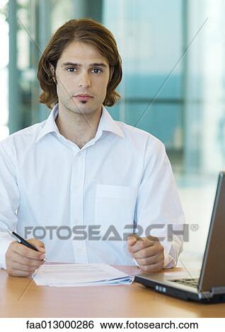 Young male executive working at desk View Large Photo Image Stock Photograph - Young male executive working at desk. Fotosearch