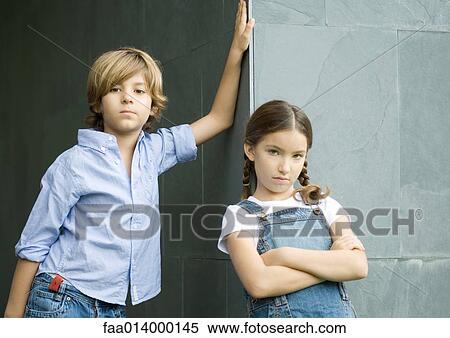 Stock Photography - Boy and girl, leaning against corner of wall, portrait. Fotosearch