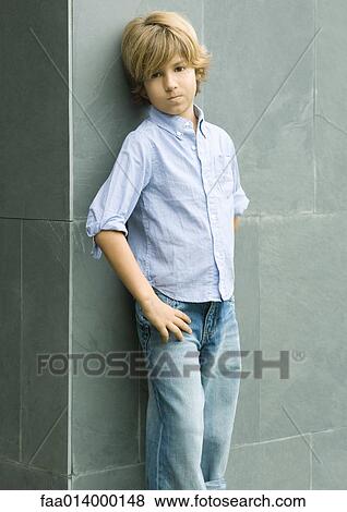 Stock Photo - Boy leaning against wall, portrait. Fotosearch