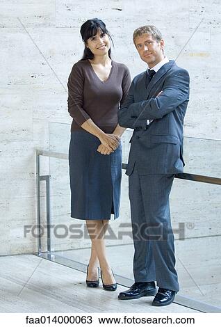 Businessman and woman, standing and smiling, portrait View Large Photo Image Stock Image - Businessman and woman, standing and smiling, portrait. Fotosearch