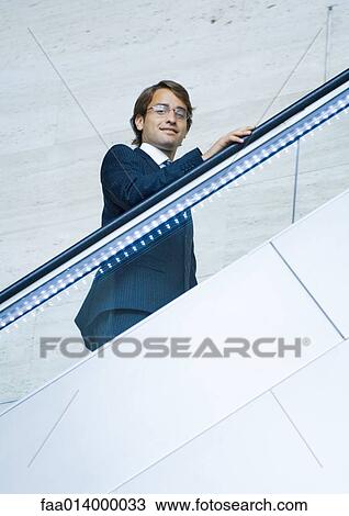 Businessman going up on escalator, portrait View Large Photo Image Stock Image - Businessman going up on escalator, portrait. Fotosearch