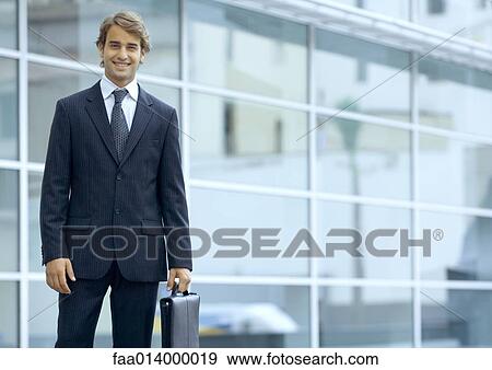 Businessman holding briefcase, portrait View Large Photo Image Stock Photo - Businessman holding briefcase, portrait. Fotosearch