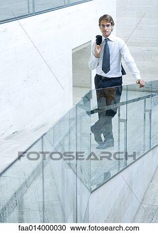 Businessman standing holding jacket over shoulder, full length portrait View Large Photo Image Stock Image - Businessman standing holding jacket over shoulder, full length portrait. Fotosearch