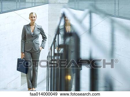 Businesswoman standing holding briefcase, hand in pocket, portrait View Large Photo Image Stock Photo - Businesswoman standing holding briefcase, hand in pocket, portrait. Fotosearch