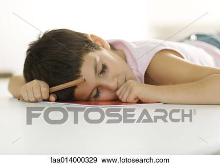 Child falling asleep with head on notebook and pencil in hand View Large Photo Image Stock Photo - Child falling asleep with head on notebook and pencil in hand. Fotosearch