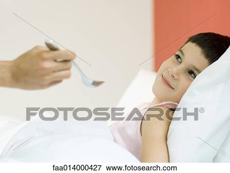 Child in bed, being fed with spoon View Large Photo Image Stock Photo - Child in bed, being fed with spoon. Fotosearch