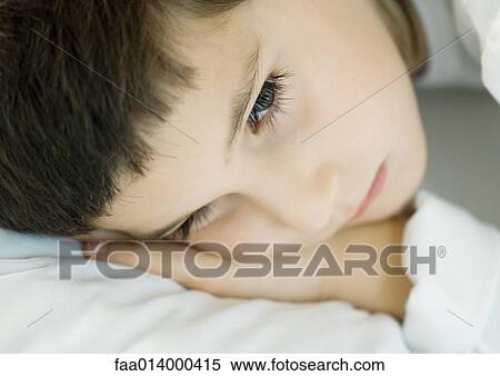 Stock Photography - Child lying down, head on pillow, close-up. Fotosearch