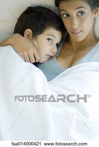 Child lying down with head on mother's shoulder View Large Photo Image Stock Image - Child lying down with head on mother's shoulder. Fotosearch