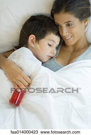 Child lying down with head on mother's shoulder, mother holding bottle of medicine View Large Photo Image Stock Image - Child lying down with head on mother's shoulder, mother holding bottle of medicine. Fotosearch