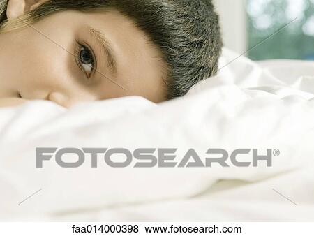 Child lying in bed, cropped view of head View Large Photo Image Stock Photo - Child lying in bed, cropped view of head. Fotosearch