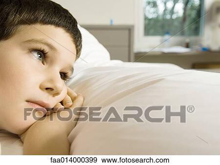 Child lying in bed, cropped view of head View Large Photo Image Stock Photo - Child lying in bed, cropped view of head. Fotosearch
