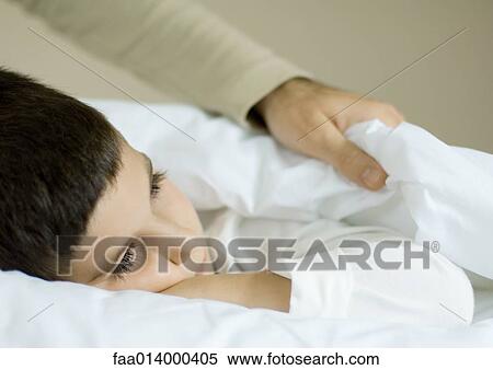 Child lying in bed, father pulling up covers View Large Photo Image Stock Photography - Child lying in bed, father pulling up covers. Fotosearch