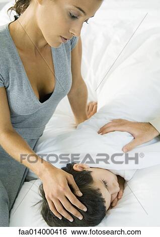 Child lying in bed, mother's hand on head and father's hand on shoulder View Large Photo Image Stock Photograph - Child lying in bed, mother's hand on head and father's hand on shoulder. Fotosearch