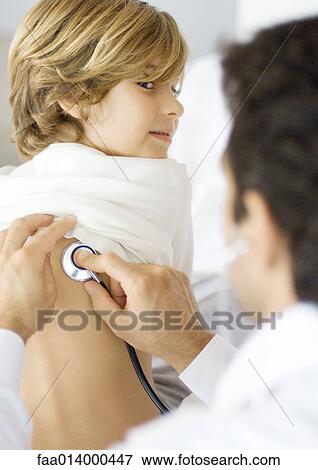 Stock Photo - Doctor holding stethoscope to boy's back. Fotosearch