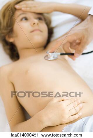 Doctor holding stethoscope to boy's chest View Large Photo Image Stock Image - Doctor holding stethoscope to boy's chest. Fotosearch