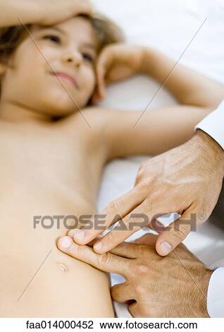 Doctor pressing fingers against boys side View Large Photo Image Stock Image - Doctor pressing fingers against boys side. Fotosearch