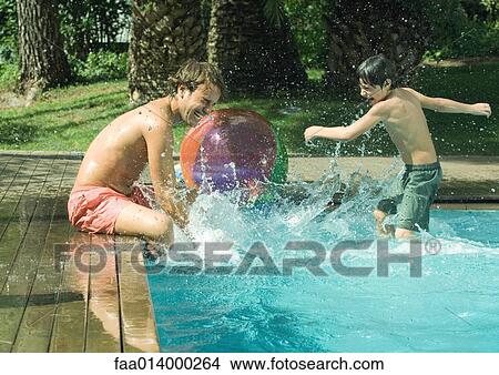 Father and son splashing in swimming pool View Large Photo Image Picture - Father and son splashing in swimming pool. Fotosearch