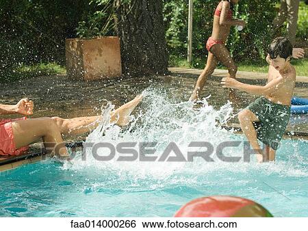 Father and son splashing in swimming pool View Large Photo Image Stock Photograph - Father and son splashing in swimming pool. Fotosearch