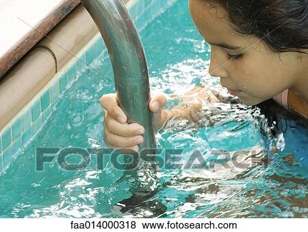Girl holding on to ladder in pool, cropped view View Large Photo Image Stock Photo - Girl holding on to ladder in pool, cropped view. Fotosearch