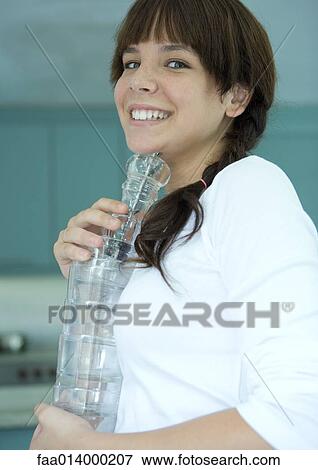 Girl holding stack of glasses, smiling View Large Photo Image Stock Photo - Girl holding stack of glasses, smiling. Fotosearch