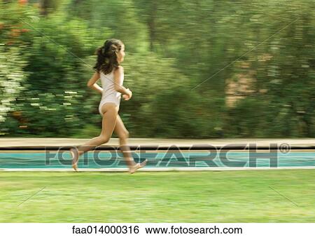 Stock Photograph - Girl in bathing suit running near swimming pool, blurred motion. Fotosearch