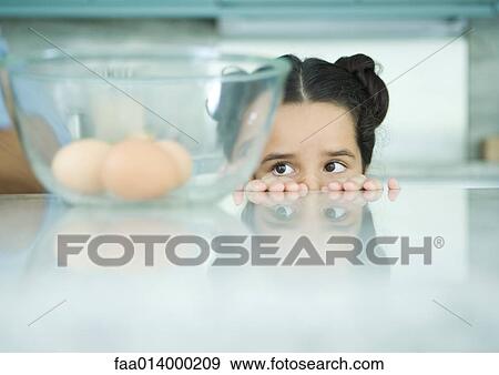 Girl looking over edge of counter at eggs in mixing bowl View Large Photo Image Stock Photo - Girl looking over edge of counter at eggs in mixing bowl. Fotosearch