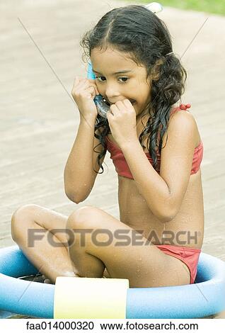 Girl sitting in ring, putting snorkel in mouth View Large Photo Image Stock Image - Girl sitting in ring, putting snorkel in mouth. Fotosearch