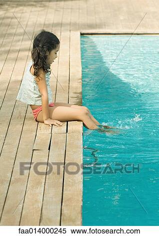 Girl sitting on edge of pool, dangling feet in water View Large Photo Image Stock Photography - Girl sitting on edge of pool, dangling feet in water. Fotosearch