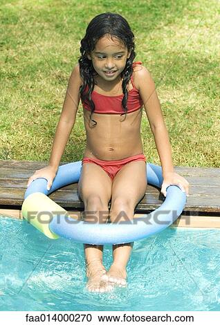 Girl sitting on edge of swimming pool View Large Photo Image Stock Image - Girl sitting on edge of swimming pool. Fotosearch