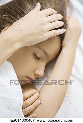 Girl sleeping in bed, mother's hand stroking head View Large Photo Image Stock Photo - Girl sleeping in bed, mother's hand stroking head. Fotosearch