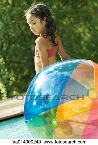 Girl standing in pool, with beach ball View Large Photo Image Stock Photo - Girl standing in pool, with beach ball. Fotosearch