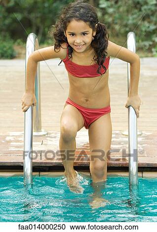 Girl standing on pool ladder, smiling at camera View Large Photo Image Stock Image - Girl standing on pool ladder, smiling at camera. Fotosearch