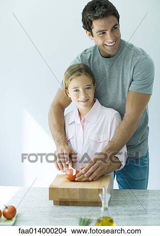 Man helping daughter cut tomatoes View Large Photo Image Picture - Man helping daughter cut tomatoes. Fotosearch