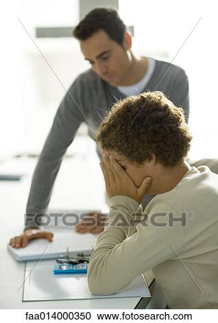 Man helping teenage son with homework View Large Photo Image Stock Image - Man helping teenage son with homework. Fotosearch