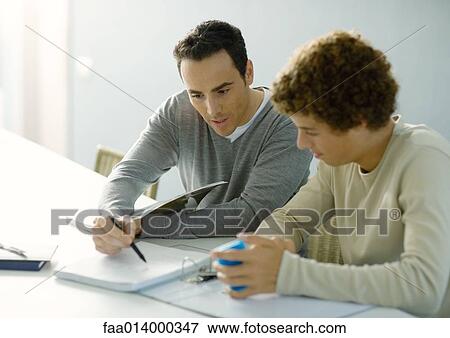 Man helping teenage son with homework View Large Photo Image Stock Photo - Man helping teenage son with homework. Fotosearch