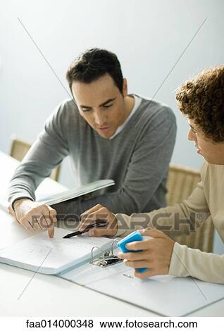Man helping teenage son with homework View Large Photo Image Stock Photo - Man helping teenage son with homework. Fotosearch